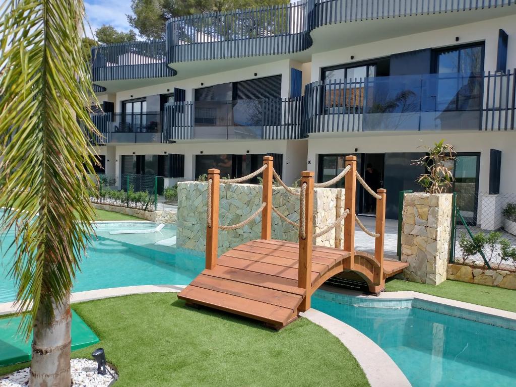 a bridge over a pool in front of a building at Modern nieuwbouwappartement aan het strand van de Mar Menor in Santiago de la Ribera in Lo Pagán