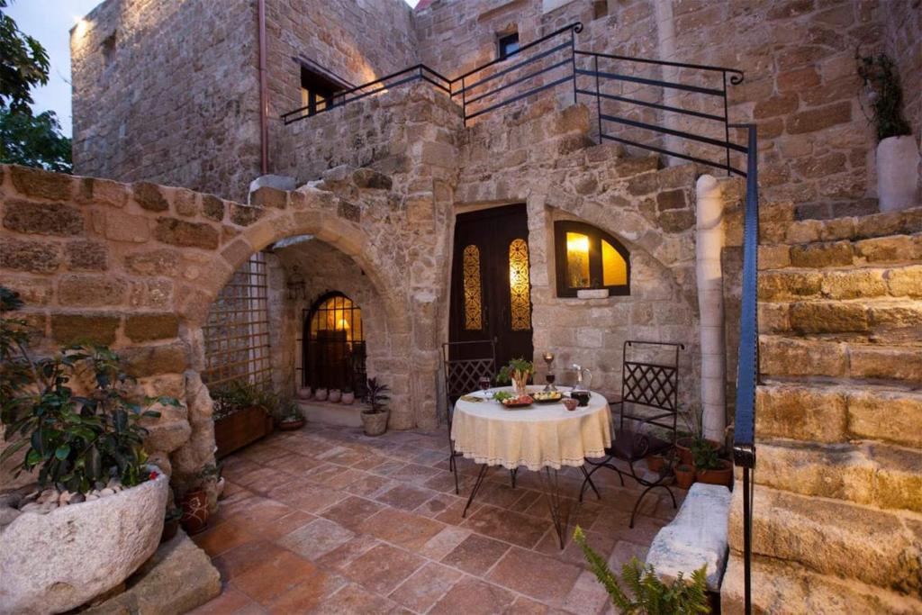 un patio con tavolo in un edificio in pietra di Porolithos Boutique Hotel a Città di Rodi