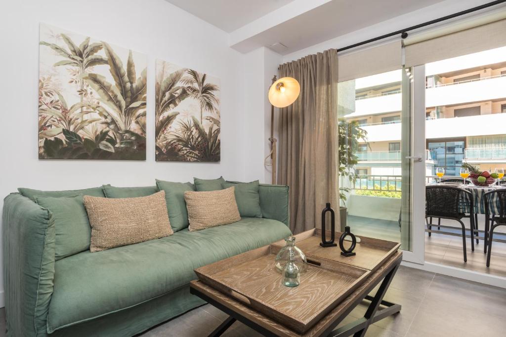 a living room with a green couch and a table at Roy Boston Marbella by Florentia Homes in Marbella