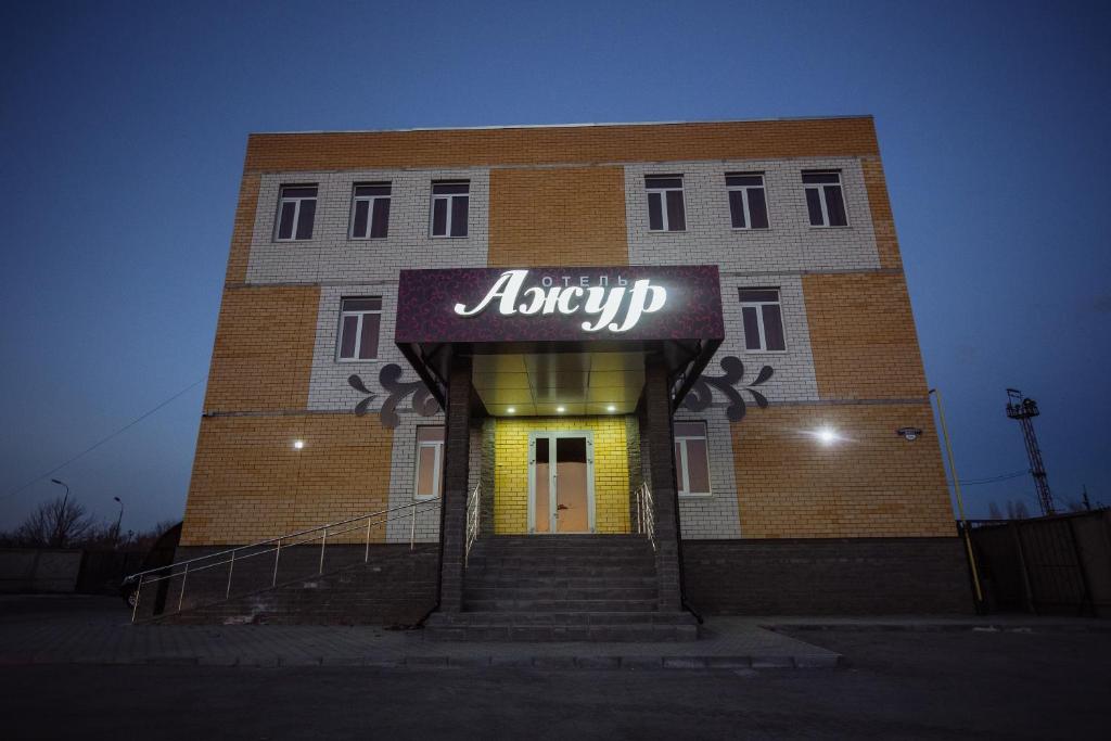 a large brick building with a sign on it at Azhur Hotel in Tambov
