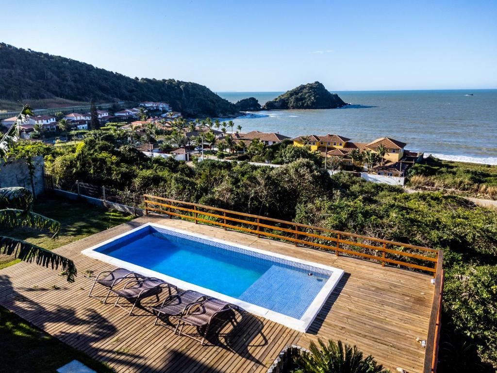 a swimming pool on a deck next to the ocean at Morada do Sol Guest House 2 in Búzios