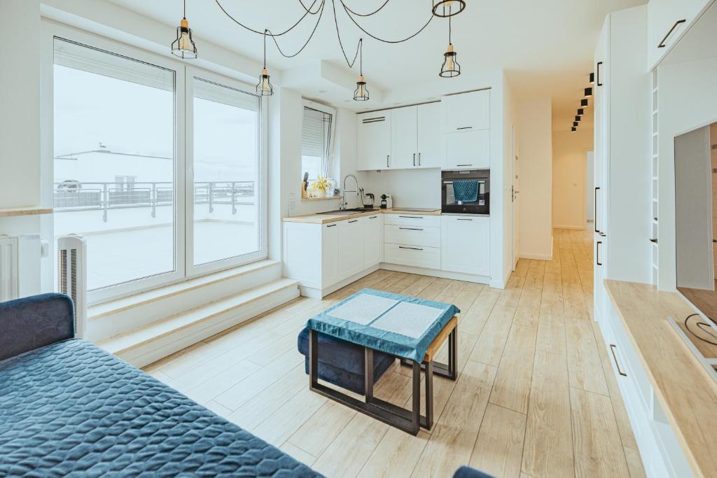 a living room with a couch and a kitchen at Apartament Szlachecka in Warsaw