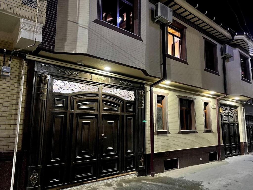 un edificio con una gran puerta de madera en una calle en Hotel Mohina, en Samarkand