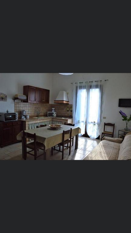 a living room with a table and a kitchen at Casa Vacanze Da Laura in San Vito lo Capo