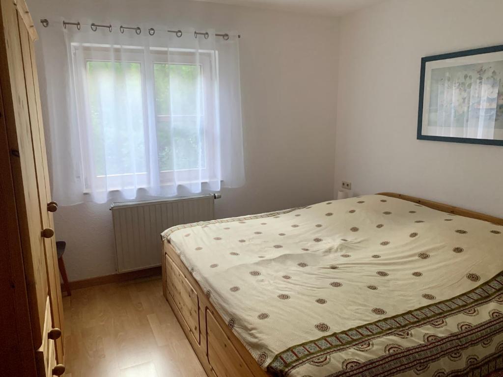 a bed in a bedroom with a window at Einladendes Appartement im Grünen für 2 Personen in Ostrach
