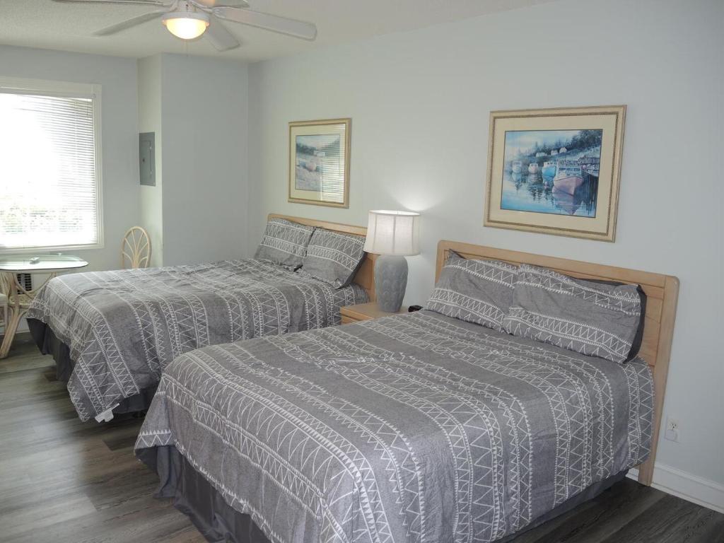 1 Schlafzimmer mit 2 Betten und einem Deckenventilator in der Unterkunft 503L villa in Calabash