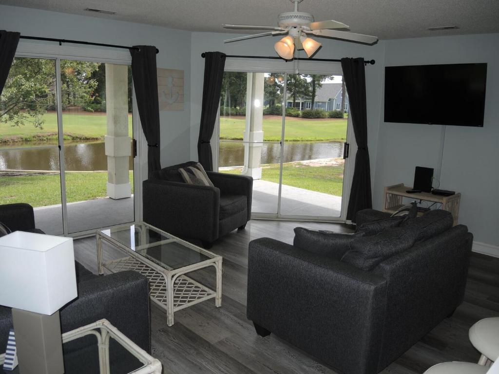 a living room with two couches and a flat screen tv at 503M villa in Calabash