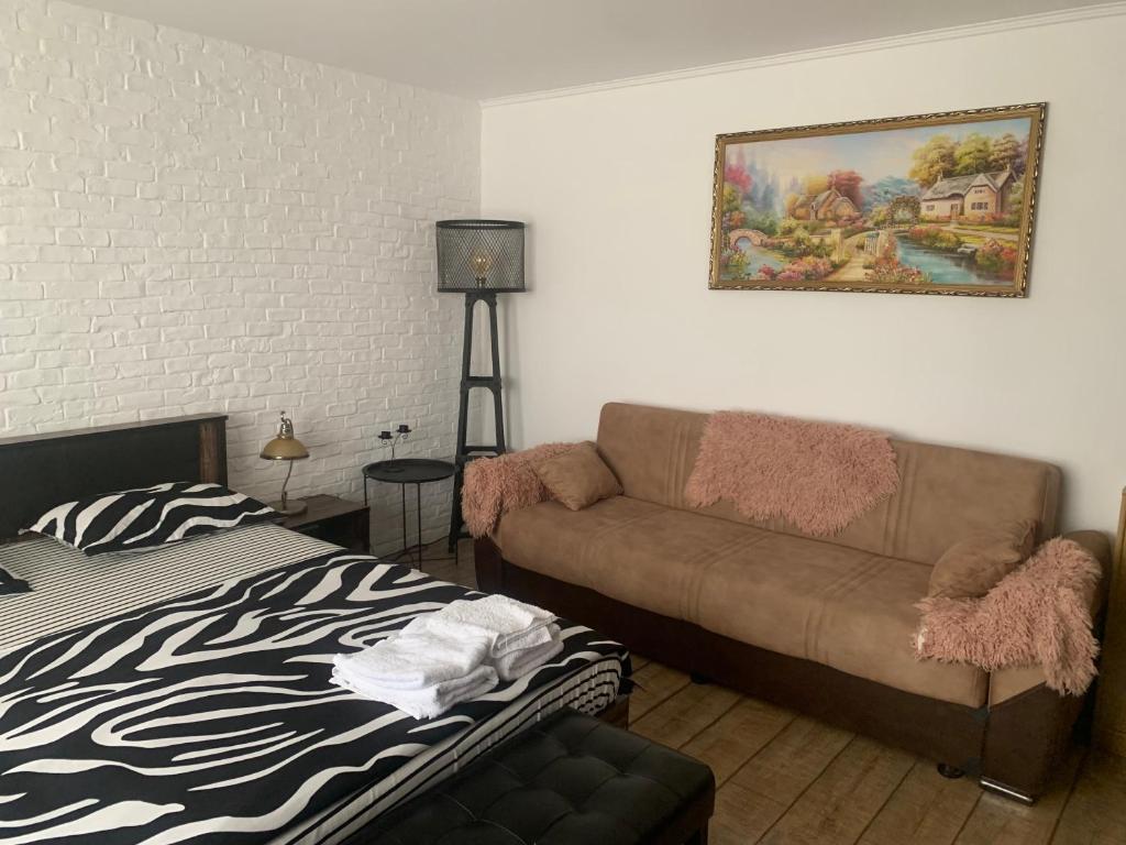 een woonkamer met een bank en een bed bij Garsoniera 1 decembrie in Alba Iulia