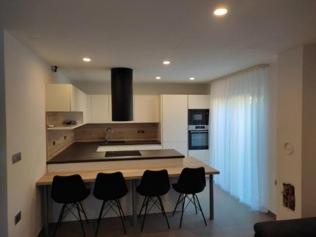 a kitchen with a island with black chairs around it at Apartment river Nadiža Podbela in Podbela