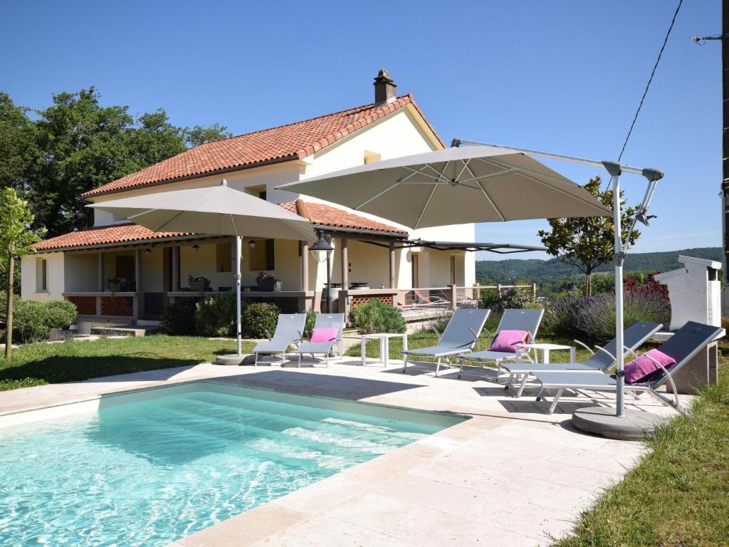 Viré的住宿－Les Poujols 6 Pers，一座房子,设有游泳池、椅子和遮阳伞