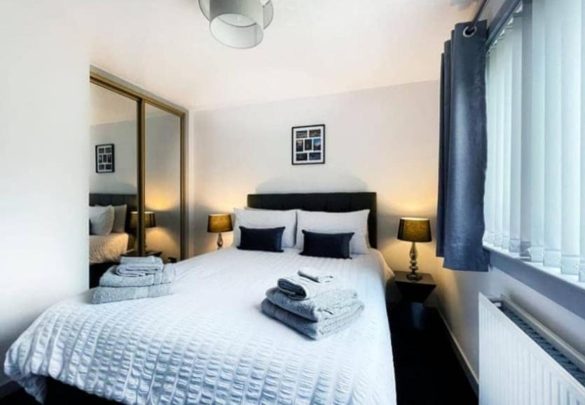 a bedroom with a white bed with towels on it at BAYVIEW in Stornoway