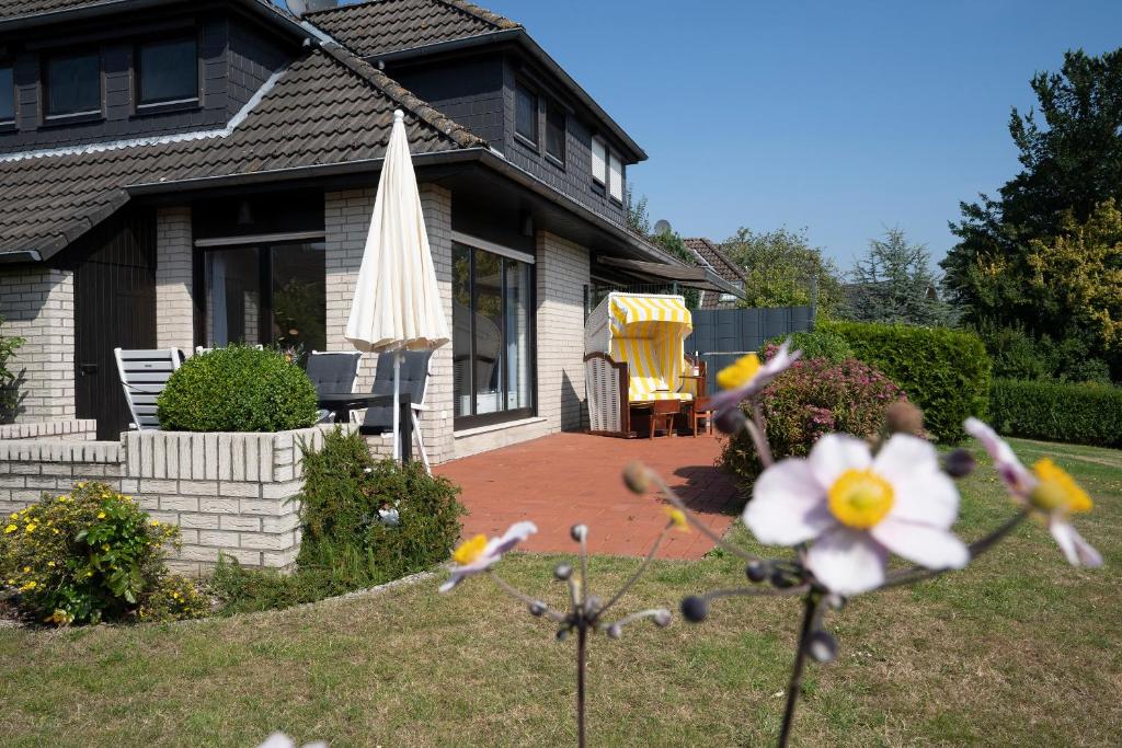 a house with a yard with a patio and an umbrella at Haus Humml in Grömitz