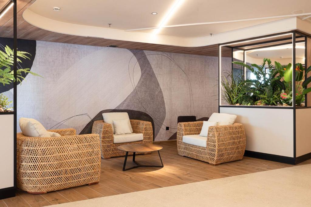 a lobby with wicker chairs and a table at Hotel Primavera Park in Benidorm