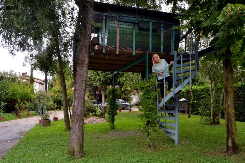 a man is climbing up a tree house at La Casa Sull'Albero in Mestre