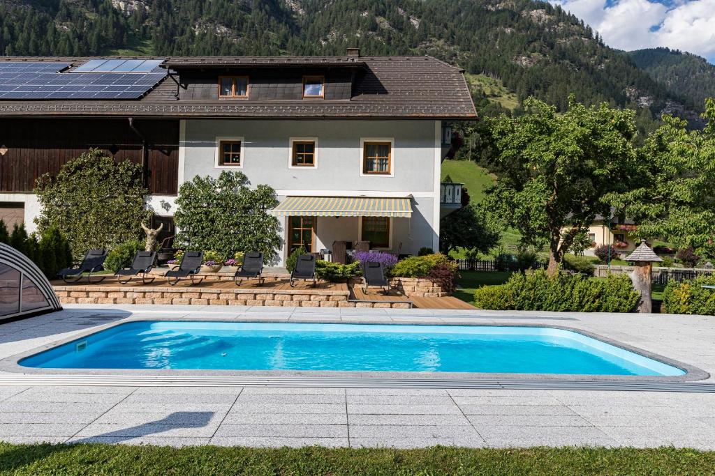 a swimming pool in front of a house at Ferienwohnung Aigner im Salzburger Lungau in Muhr