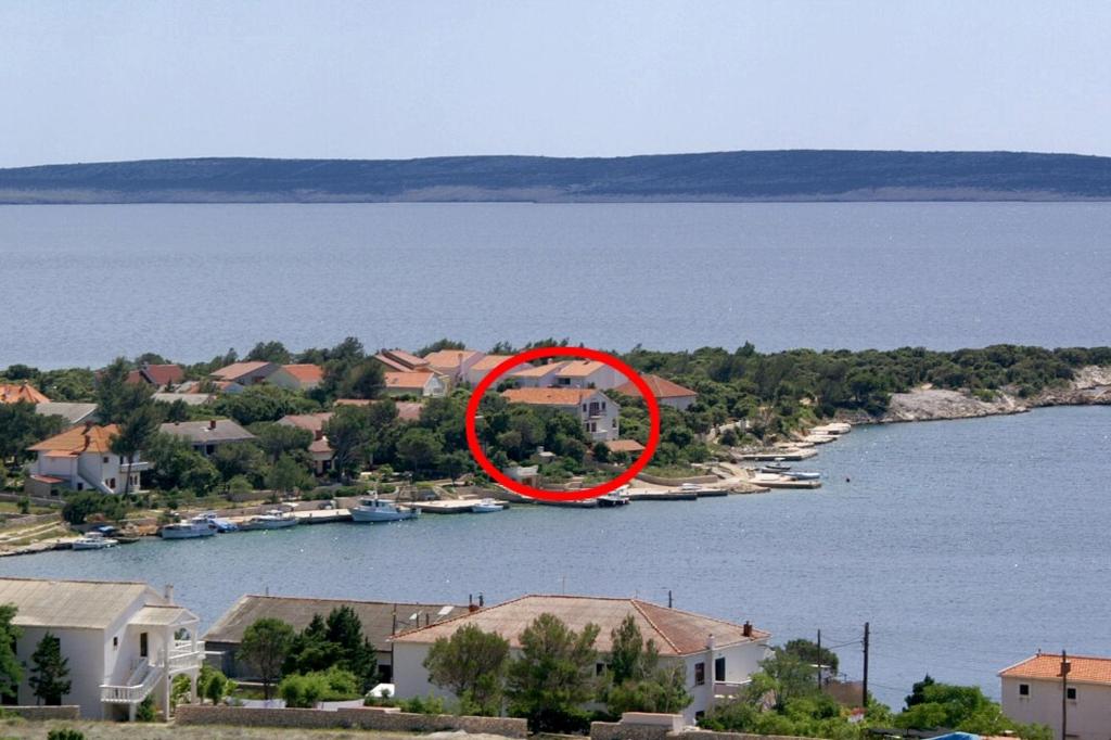 a red circle on a house in the middle of a lake at Apartments by the sea Simuni, Pag - 236 in Kolan
