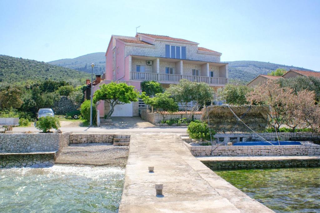 una casa en medio de un cuerpo de agua en Apartments by the sea Kneza, Korcula - 167, en Račišće