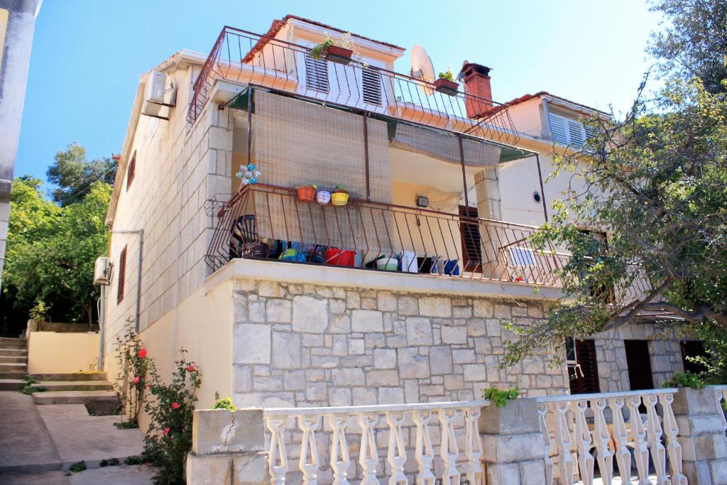 a house with a balcony and a fence at Apartments by the sea Brna, Korcula - 171 in Smokvica