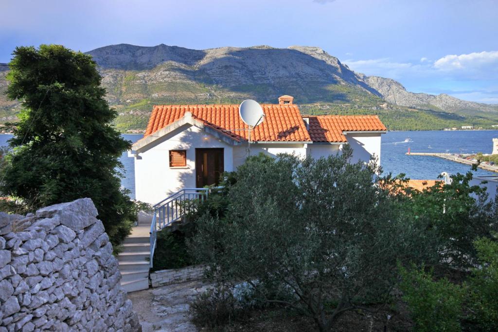 Cette maison blanche offre une vue sur l'eau et les montagnes. dans l'établissement Apartments by the sea Korcula - 157, à Korčula