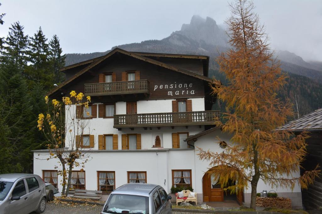 a large white building with a balcony on it at Locanda Pensione Maria in Vigo di Fassa