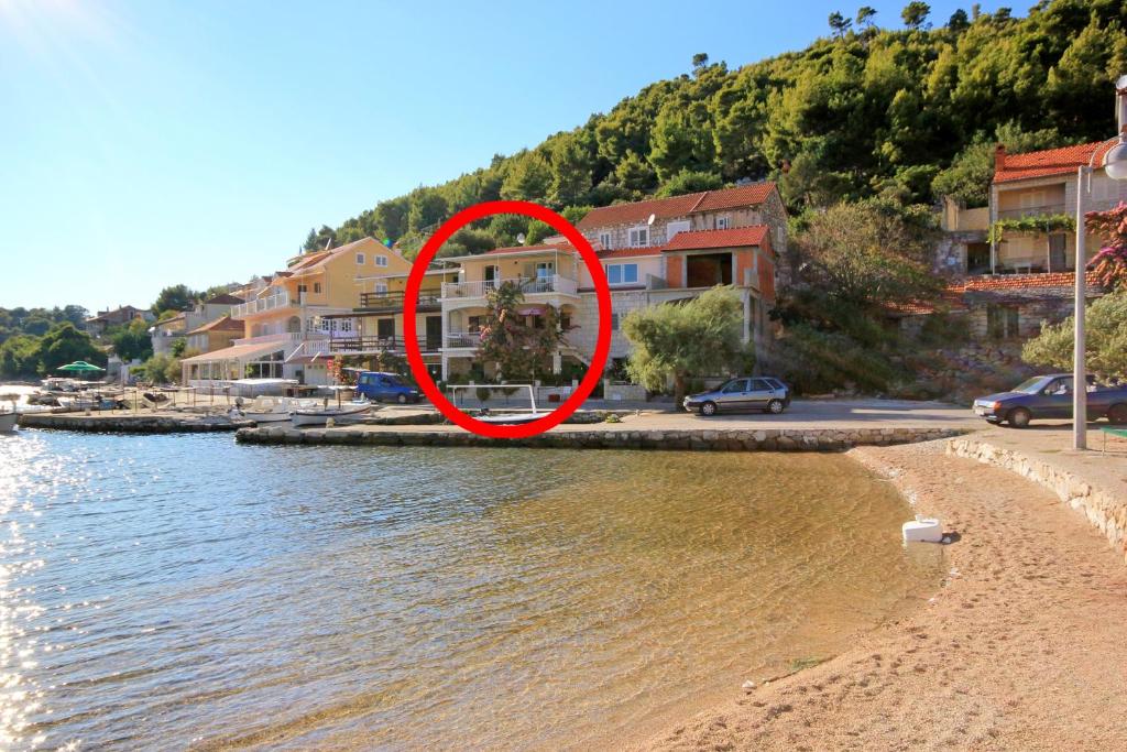 a red circle on a beach next to the water at Apartments by the sea Grscica, Korcula - 169 in Prizba