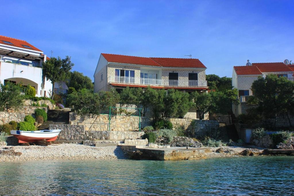 ein Haus am Ufer eines Wasserkörpers in der Unterkunft Apartments by the sea Tri Zala, Korcula - 174 in Korčula