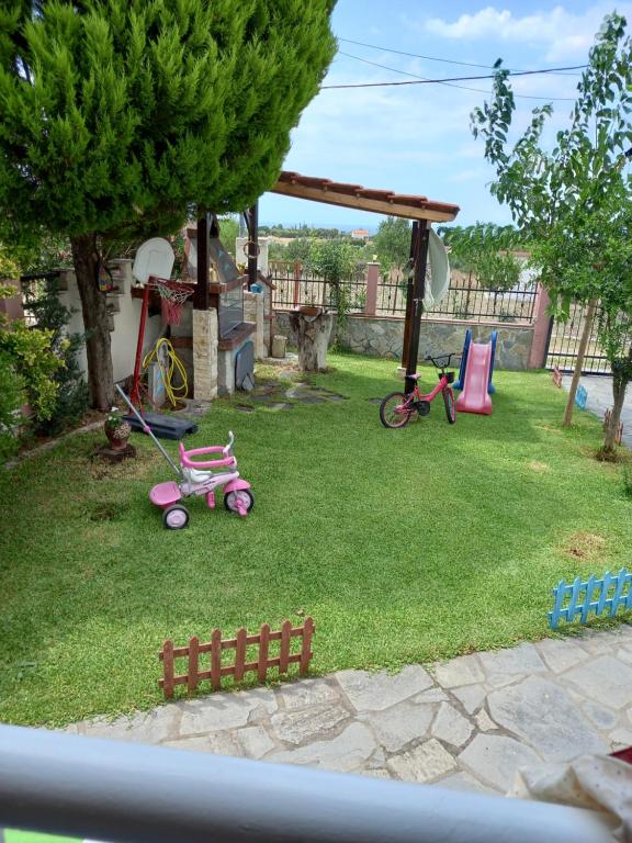 a yard with a playground with two pink childrens toys at Our Country House in Vergia