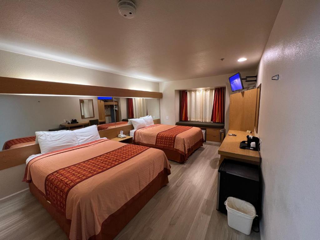 a hotel room with two beds and a television at Americas Best Value Inn and Suites Ada in Ada