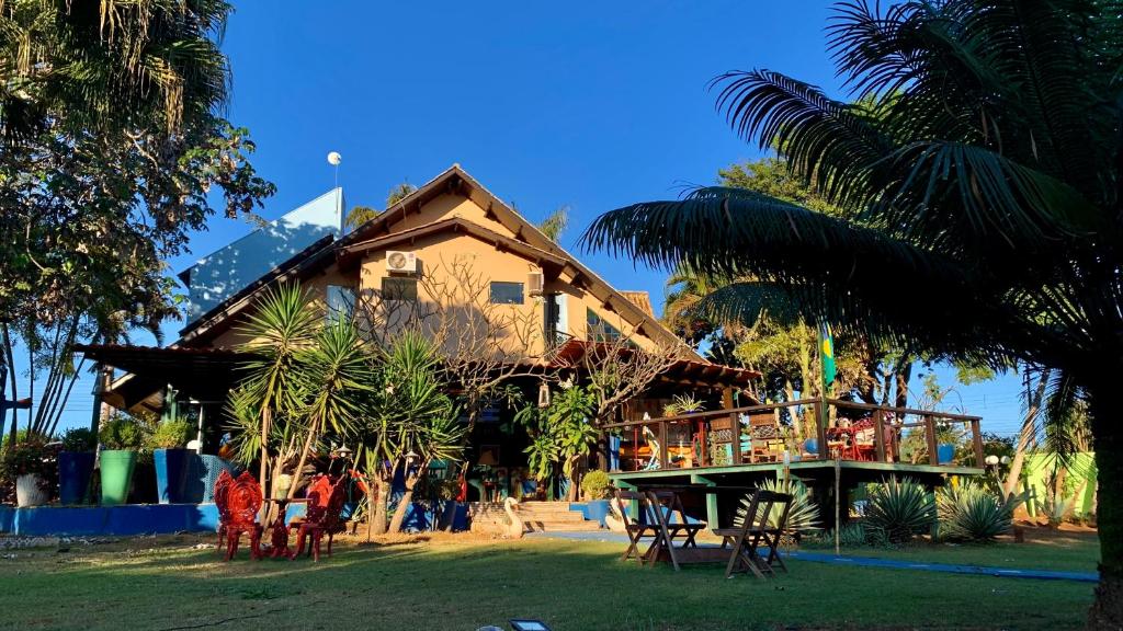 um edifício com pessoas sentadas em cadeiras em frente dele em Pousada Vilagio Chapada em Chapada dos Guimarães