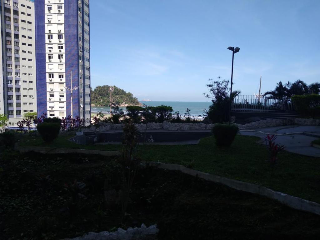 a park with buildings and the ocean in the background at Apartamento Pé na Areia com Vista Mar e Wi-fi LOFTJL com 01 vaga de garagem sujeita a disponibilidade in Santos