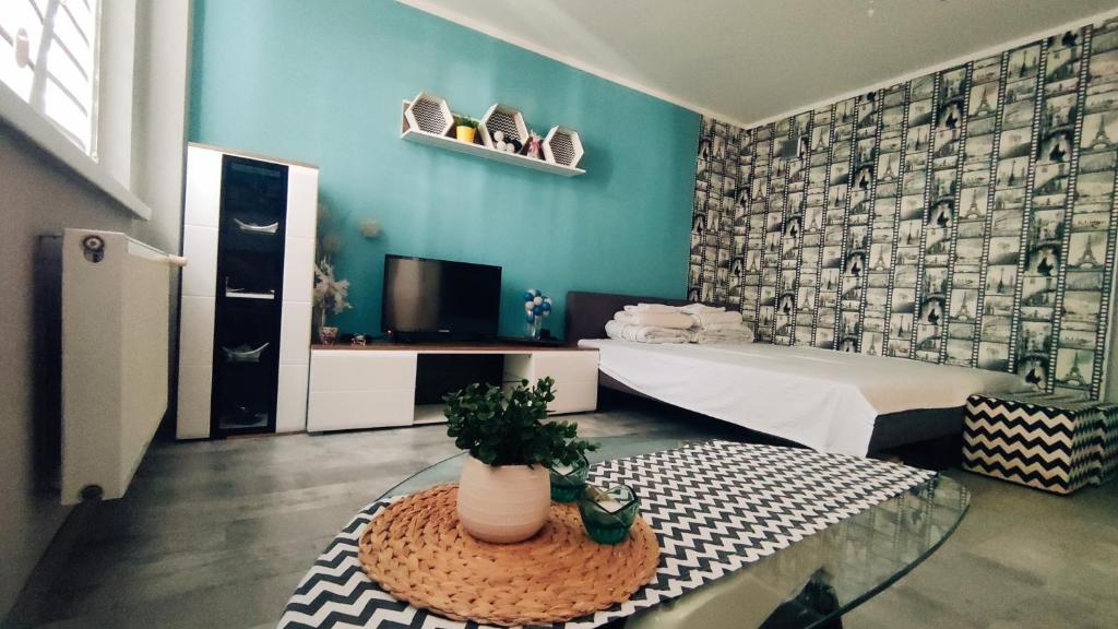une chambre avec un lit et une table avec une plante dans l'établissement Apartament 25, à Płock