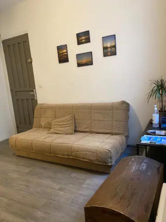 um sofá numa sala de estar com fotografias na parede em Appartement 4 couchages - Port ciotat em La Ciotat