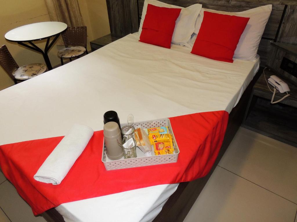 uma cama grande com uma colcha vermelha e branca em Hotel São Judas - Próximo a Expo São Paulo em São Paulo