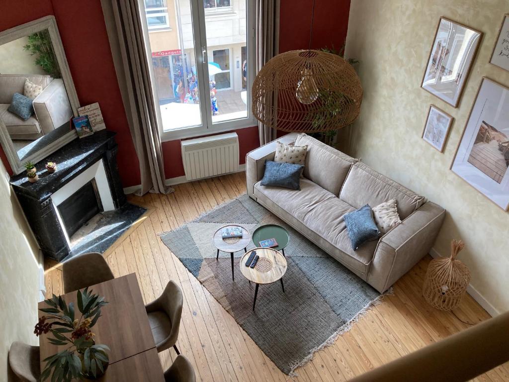 uma sala de estar com um sofá e uma mesa em Appartement cosy au cœur de la ville d’été em Arcachon