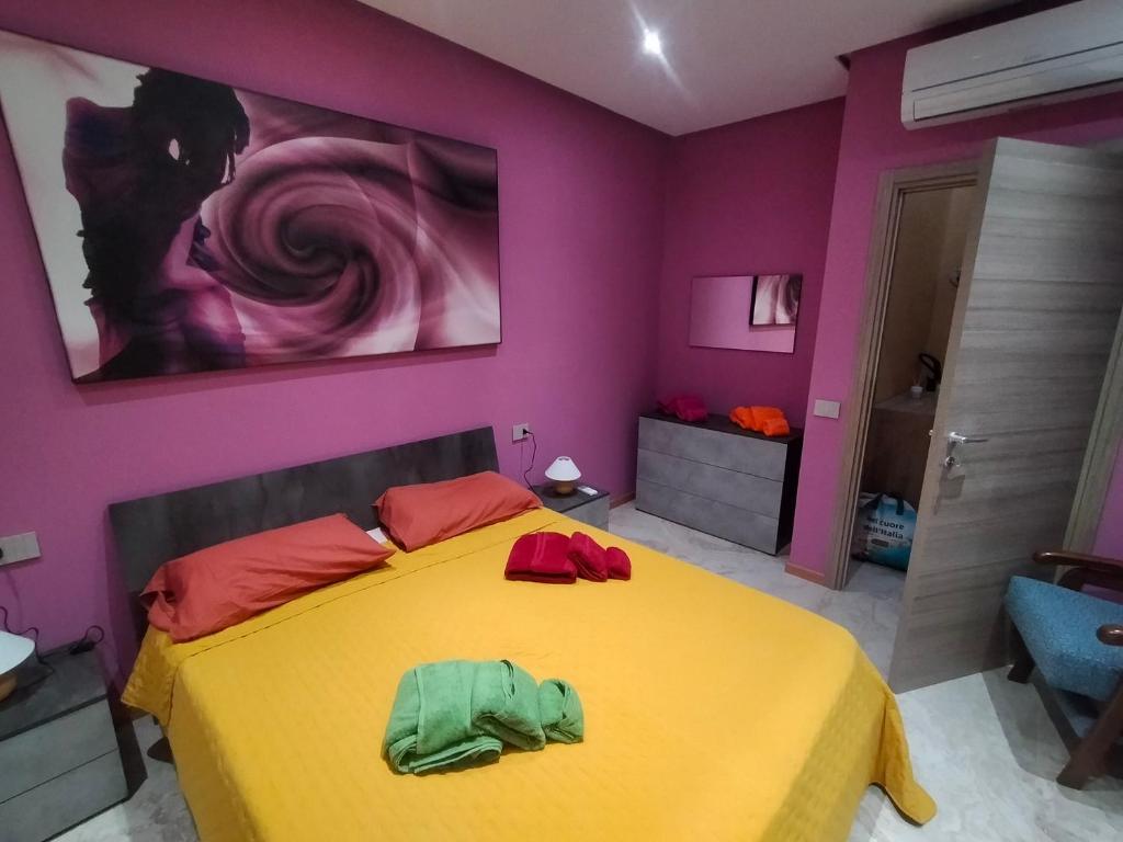 a bedroom with a yellow bed and purple walls at La Selva Incantevole Appartamento in Colazza