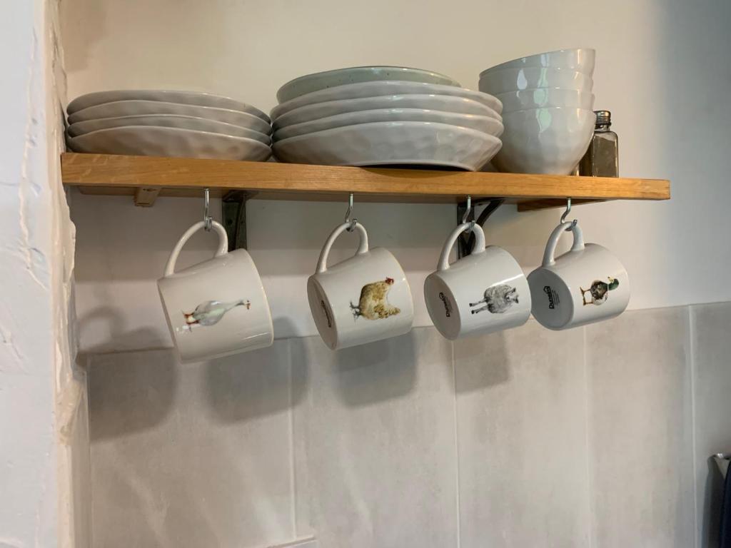 a shelf with plates and bowls on it at Molehill lodge in Swansea