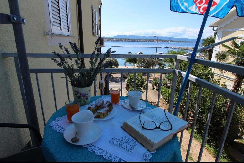 a blue table with food and glasses on a balcony at City center studio apartment in Malinska