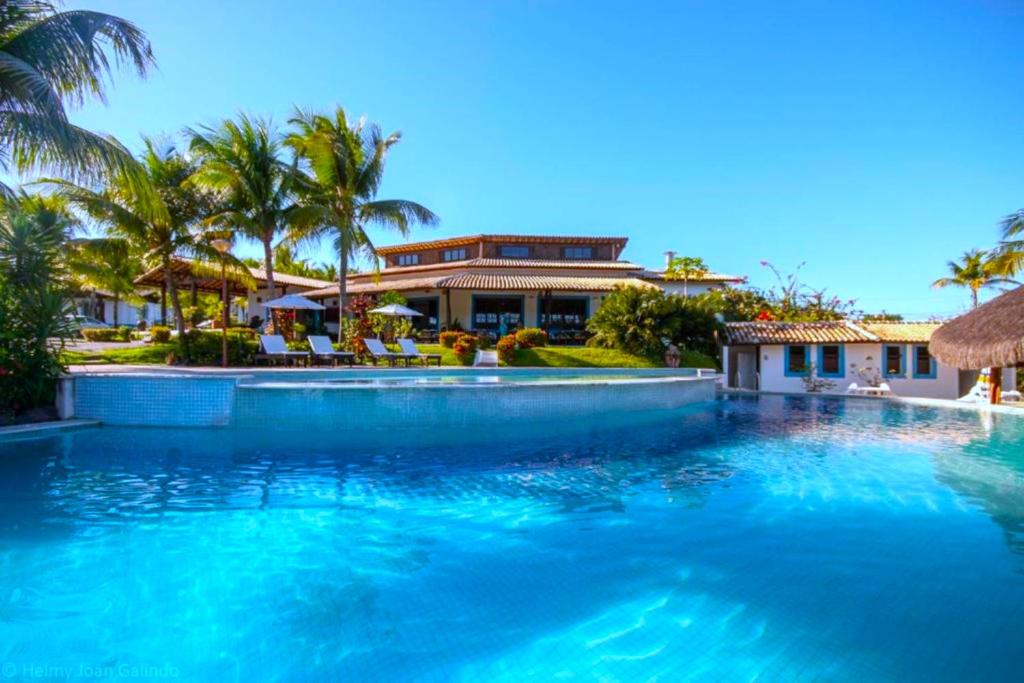 a large swimming pool in front of a house at Hotel Tibau Lagoa in Pipa