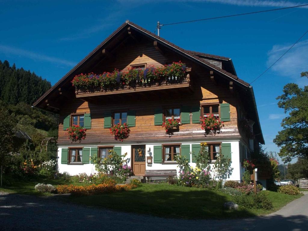 a wooden house with flower boxes on it at Ferienhof Reichart in Scheidegg