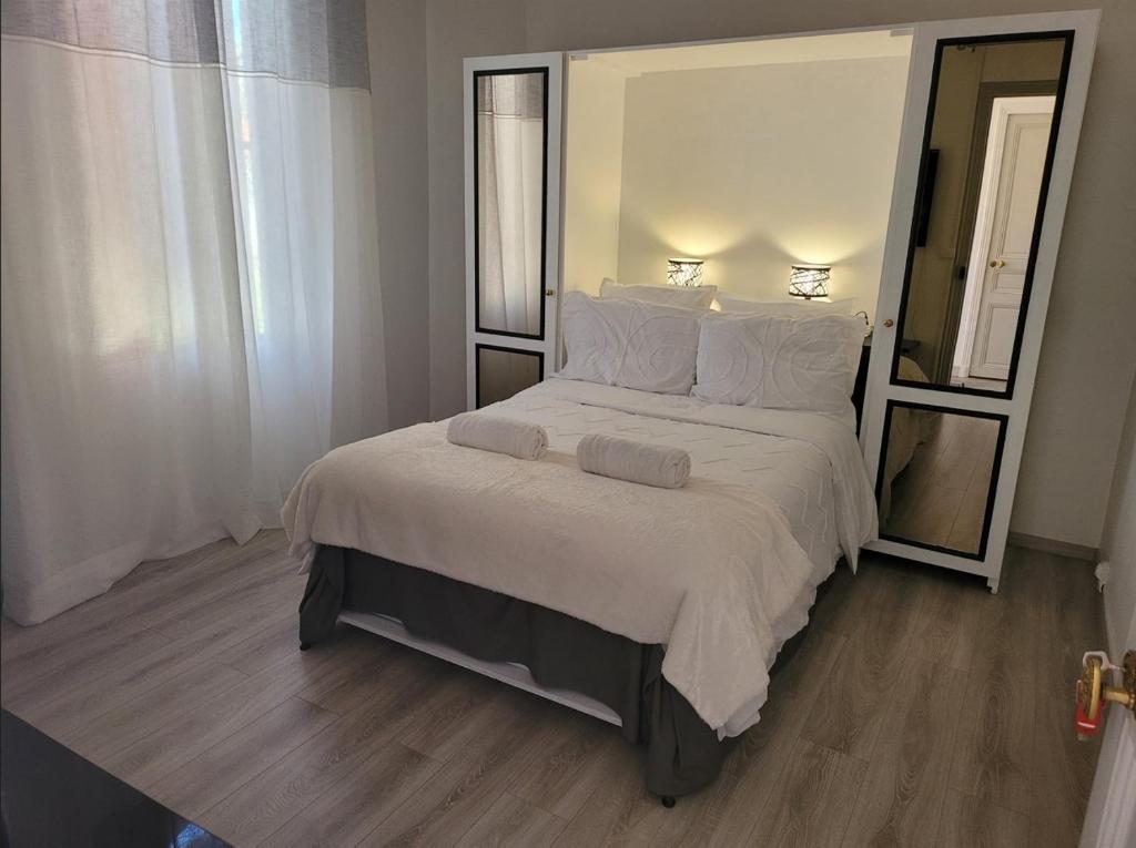 ein Schlafzimmer mit einem großen Bett mit weißer Bettwäsche und Kissen in der Unterkunft 1 Chambre paisible à La Trinité proche de Nice et Monaco in La Trinité