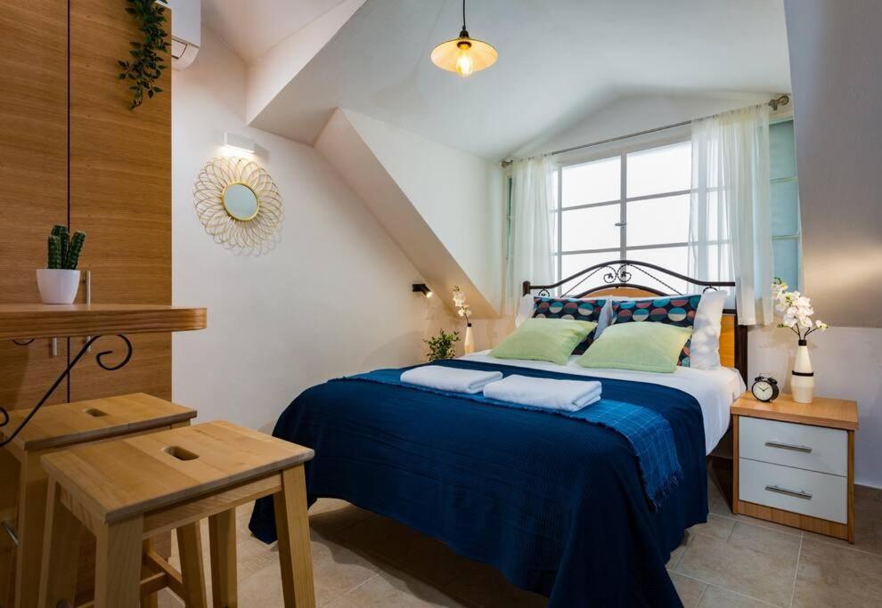 um quarto com uma cama com lençóis azuis e uma janela em Ovadia Somech #6 em Jerusalém