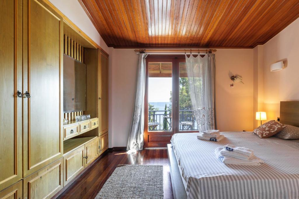 a bedroom with two beds and a large window at Luna Villa Private Beach in Nea Iraklia