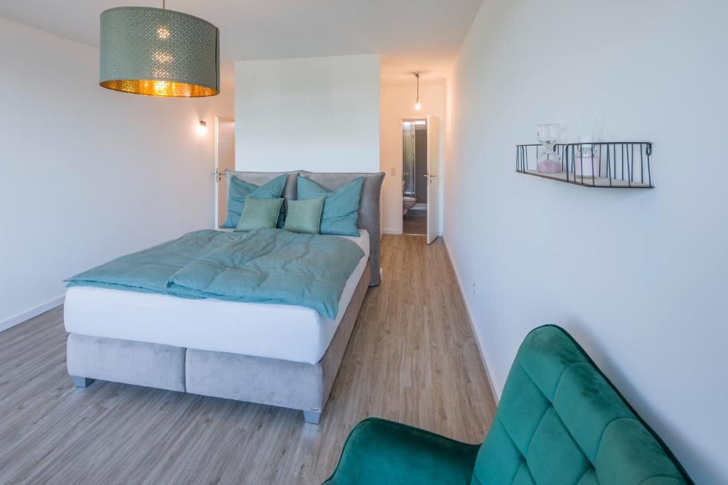 a bedroom with a bed and a green chair at Apartment im Herzen von Braunschweig mit Parkplatz in Braunschweig