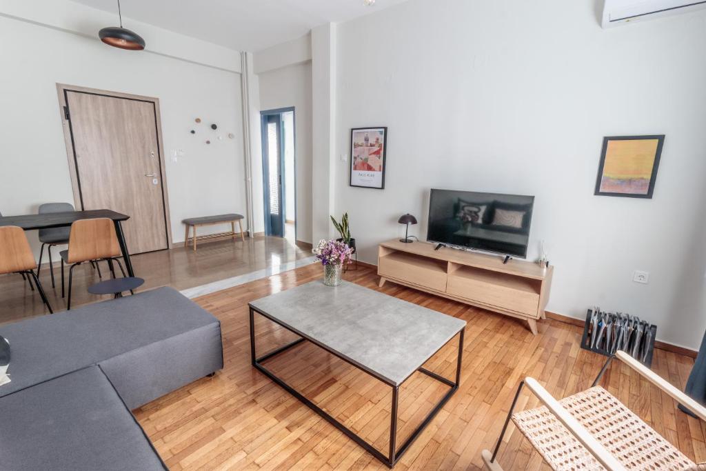 a living room with a table and a tv at Hamaretou Apartment in Sparti