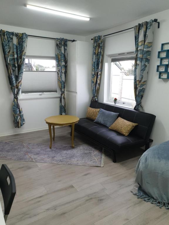 a living room with a couch and a table at Comfortable apartment, 10min Airport in Stavanger