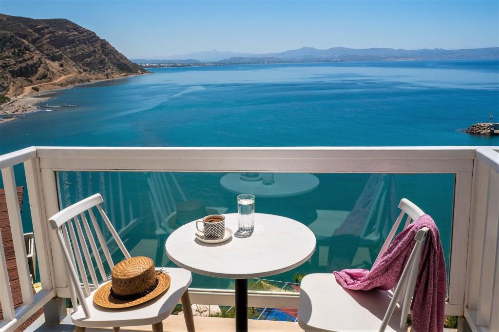 einen Tisch und Stühle mit Blick auf das Wasser in der Unterkunft Galini Mare in Agia Galini