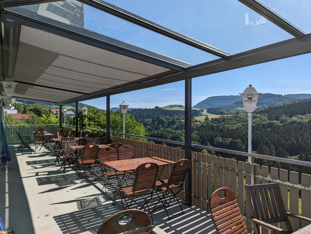 a patio with tables and chairs and a view of the mountains at Gasthof Hirsch in Waldstetten