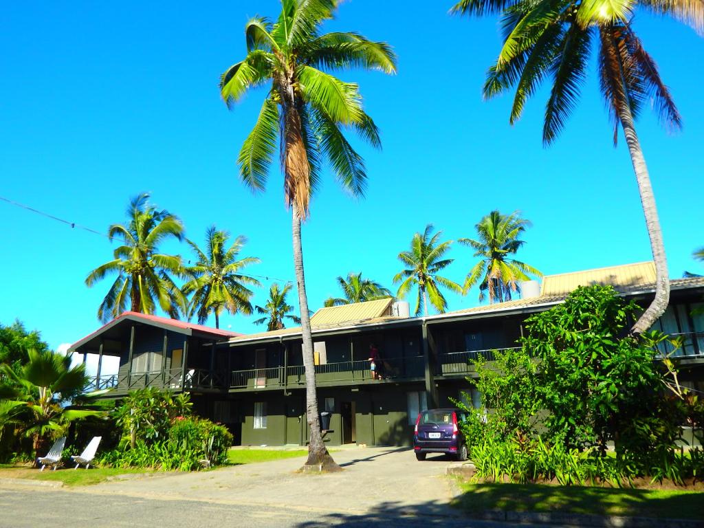 a building with palm trees in front of it at Bamboo Backpackers in Nadi