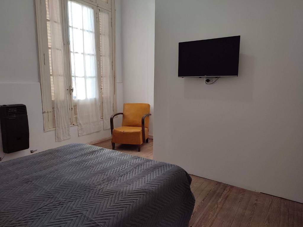 a bedroom with a bed and a flat screen tv on a wall at La Emilia in San Pedro