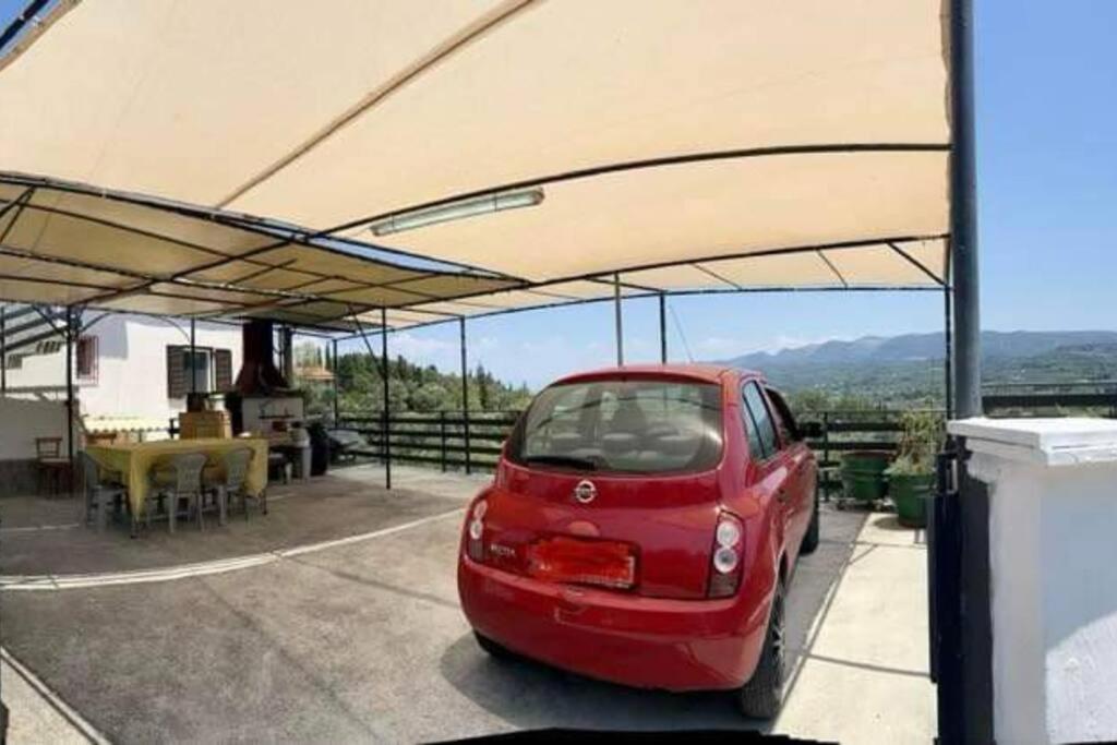 a red car parked under a large canopy at Casa di nonna in Kavalloúrion